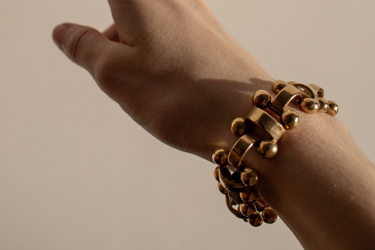 A woman wears a bangle bracelet on her outstretched arm.